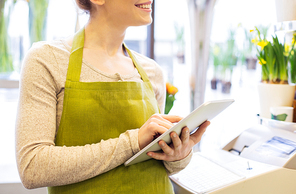 people, business, technology, sale and floristry and concept - close up of happy smiling florist woman with tablet pc computer at flower shop