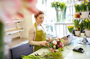 people, business,  and floristry concept - happy smiling florist woman making bunch at flower shop