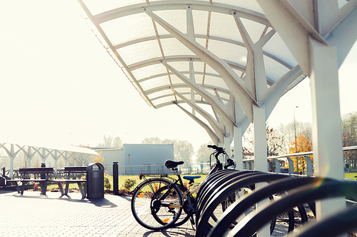 transport, storage and safety concept - close up of bicycle street parking outdoors