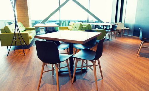 design, public place, furniture and interior concept - close up of restaurant interior with table and chairs