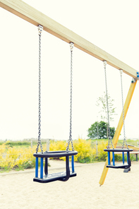 childhood, equipment and object concept - baby swing on playground outdoors