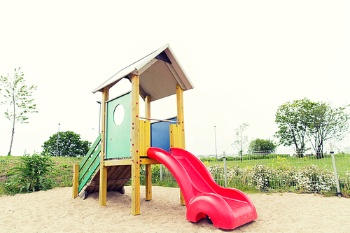 childhood, equipment and object concept - slide on playground outdoors