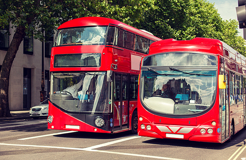 city life and public transport concept - city street with red double decker buses in london