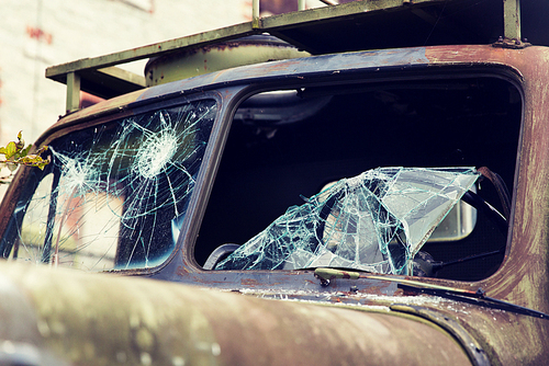 wartime, damage and danger concept - war truck with broken windshield glass outdoors