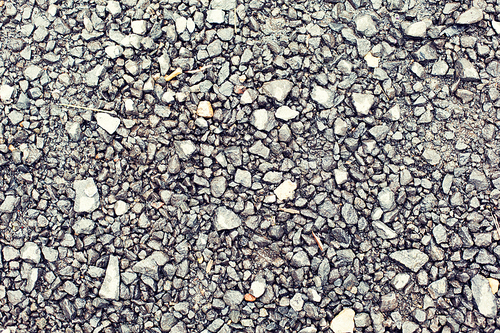 background and texture concept - close up of gray macadam stones on ground