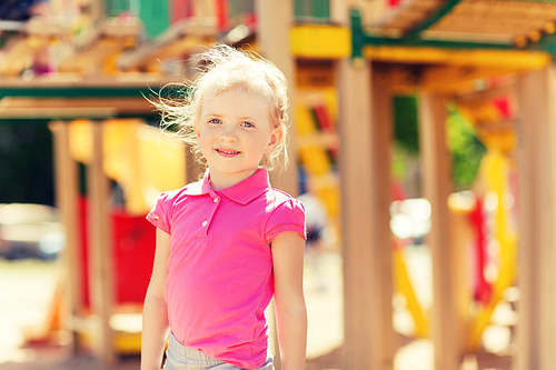 summer, childhood, leisure and people concept - happy little girl on children playground