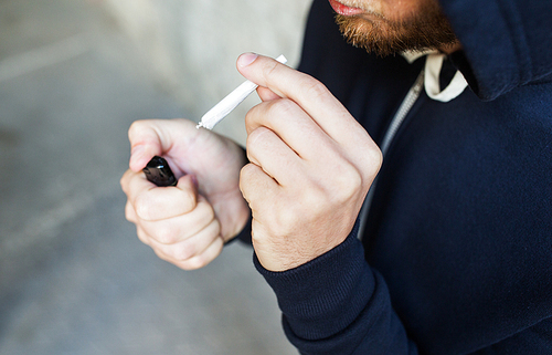 drug use, substance abuse, addiction, smoking and people concept - close up of addict hands with marijuana joint and lighter