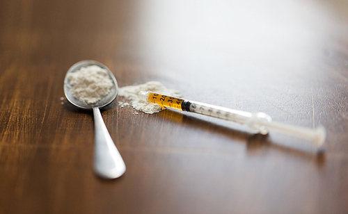 drug use, crime, addiction and substance abuse concept - close up of spoon and syringe with crack cocaine drug dose