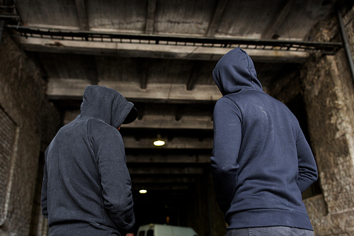 criminal activity, addiction, people and social problem concept - close up of addict men or criminals in hoodies on street