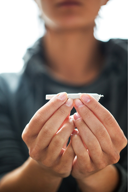 drug use, substance abuse, addiction and people concept - close up of addict hands with marijuana joint