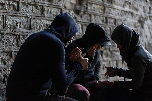 substance abuse, addiction and bad habits concept - close up of young people smoking cigarettes outdoors