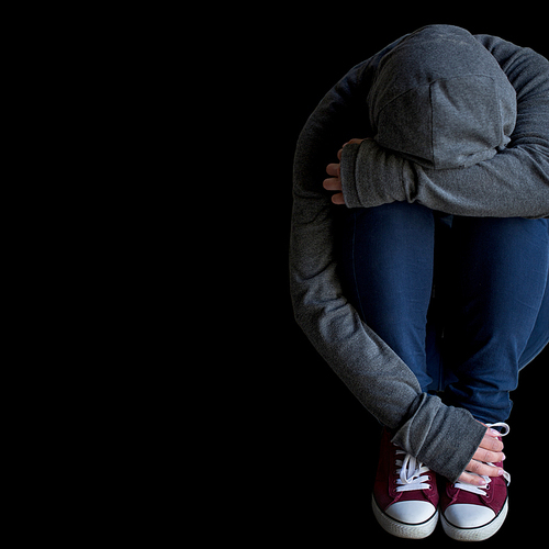 depression, drug addiction, people and social issue concept - close up of person hiding her face over blank black background