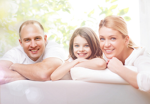 family, children, people and adoption concept - smiling parents and little girl over green natural background