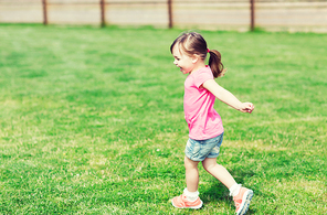 summer, childhood, leisure and people concept - happy little girl running on green summer field