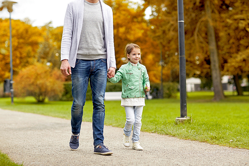 family, parenthood, fatherhood, adoption and people concept - happy father and little girl walking in autumn city park
