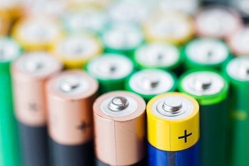 recycling, energy, power, environment and ecology concept - close up of alkaline batteries heap