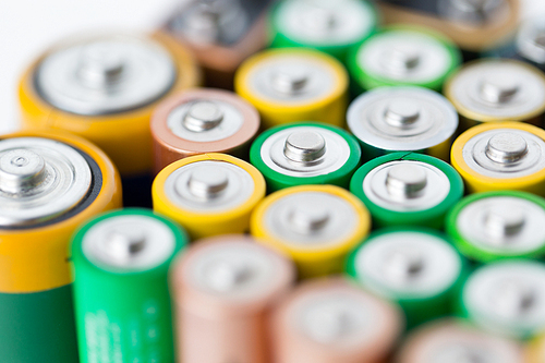 recycling, energy, power, environment and ecology concept - close up of alkaline batteries heap