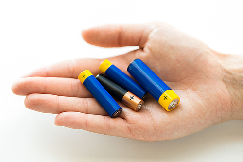 recycling, energy, power, environment and ecology concept - close up of hands holding alkaline batteries heap