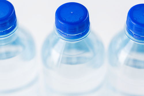 recycling, healthy eating, industry, packing and food storage concept - close up of plastic bottles with pure  water