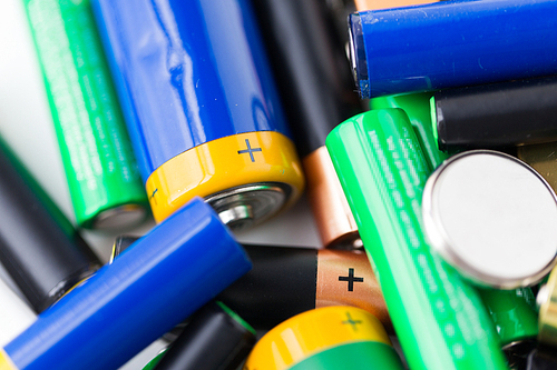 recycling, energy, power, environment and ecology concept - close up of alkaline batteries heap