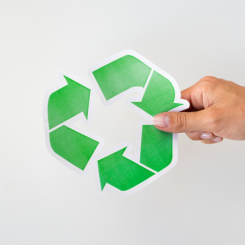waste recycling, reuse, garbage disposal, environment and ecology concept - close up of hand holding green recycle symbol