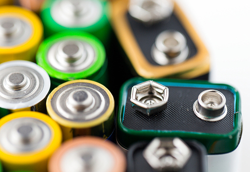 recycling, energy, power, environment and ecology concept - close up of alkaline batteries heap