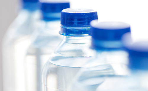 recycling, healthy eating, industry, packing and food storage concept - close up of plastic bottles with pure  water