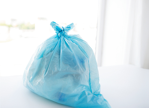 waste recycling, reuse, garbage disposal, environment and ecology concept - close up of rubbish bag with trash or garbage at home