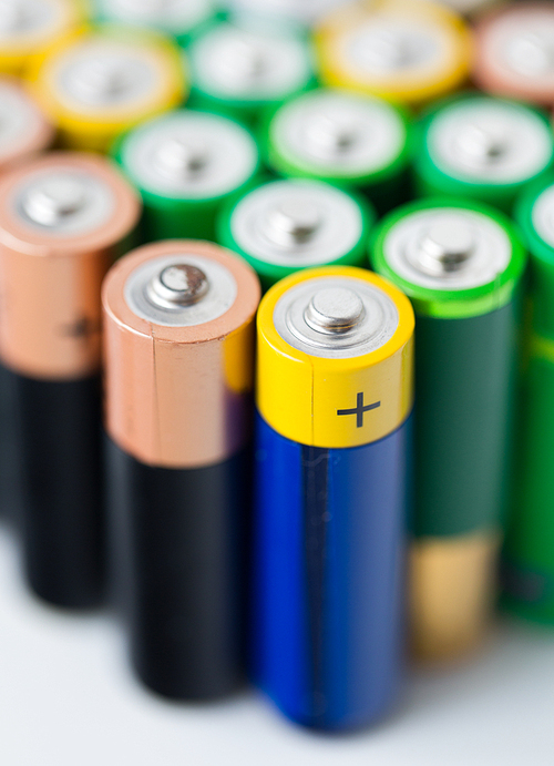 recycling, energy, power, environment and ecology concept - close up of alkaline batteries heap