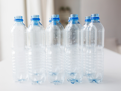 recycling, healthy eating and food storage concept - close up of clean empty used plastic water bottles on table