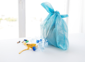 waste recycling, reuse, garbage disposal, environment and ecology concept - close up of rubbish bag with trash or garbage at home