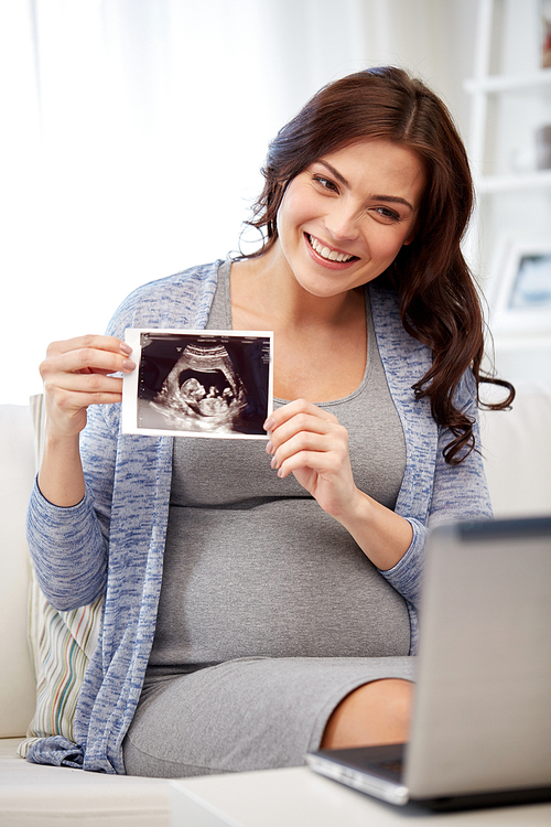 pregnancy, motherhood, people and medicine concept - happy pregnant woman with laptop computer having video call and showing ultrasound image at home