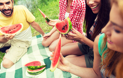 travel, tourism, hike, picnic and people concept - close up of of happy friends with tent eating watermelon at camping