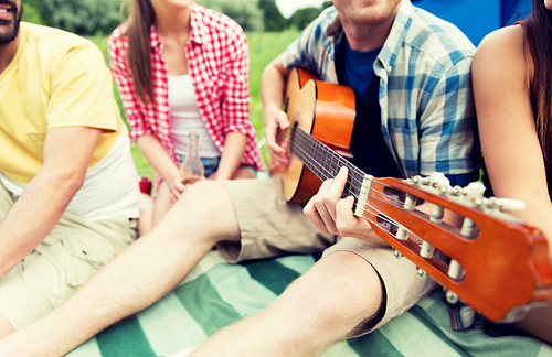 travel, tourism, hike, picnic and people concept - group of happy friends with tent and drinks playing guitar at camping