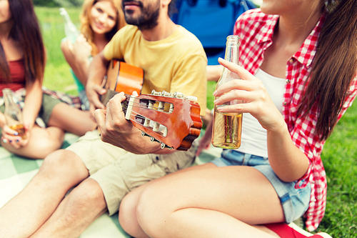 travel, tourism, hike, picnic and people concept - group of happy friends with tent and drinks playing guitar at camping