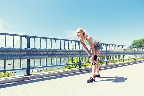 fitness, sport, exercising and healthy lifestyle concept - young woman with knee support brace on leg outdoors