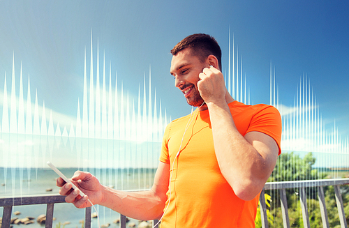 fitness, sport, people, technology and healthy lifestyle concept - smiling young man with smartphone and earphones listening to music at summer seaside over sound wave or signal diagram