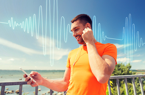 fitness, sport, people, technology and healthy lifestyle concept - smiling young man with smartphone and earphones listening to music at summer seaside over sound wave or signal diagram