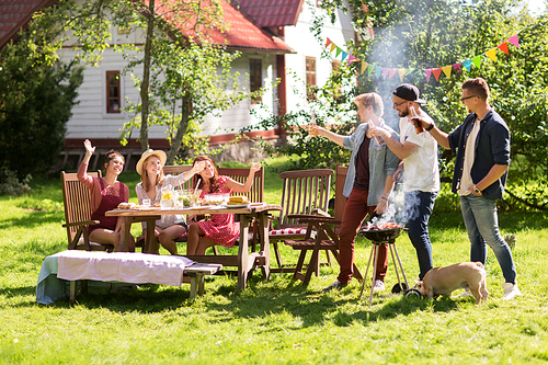 leisure, food, people, friendship and holidays concept - happy friends cooking meat on barbecue grill and drinking beer at summer outdoor party