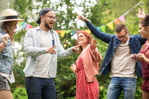 leisure, holidays, fun and people concept - happy friends dancing at summer party in garden