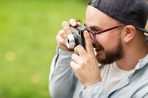 photography and people concept - close up of young man with camera photographing outdoors