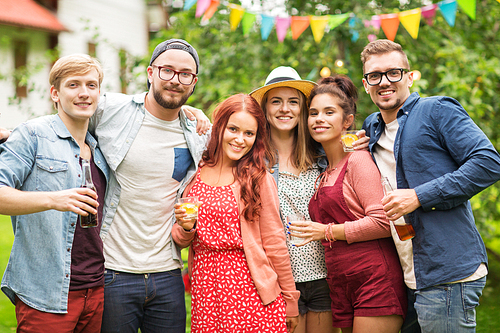 leisure, holidays, people, reunion and celebration concept - happy friends with drinks at summer garden party