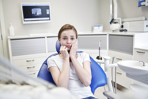 people, medicine, stomatology and phobia concept - scared and terrified patient girl at dental clinic office