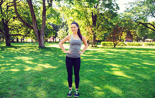 fitness, sport, people and healthy lifestyle concept - happy young woman exercising outdoors