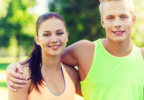 fitness, sport, friendship and healthy lifestyle concept - group of happy teenage friends or sportsmen couple hugging outdoors