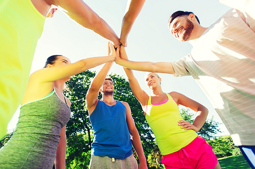 fitness, sport, friendship and healthy lifestyle concept - group of happy teenage friends or sportsmen making high five outdoors