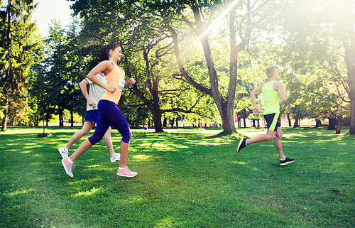 fitness, sport, friendship, race and healthy lifestyle concept - group of happy teenage friends or sportsmen running marathon with badge numbers outdoors