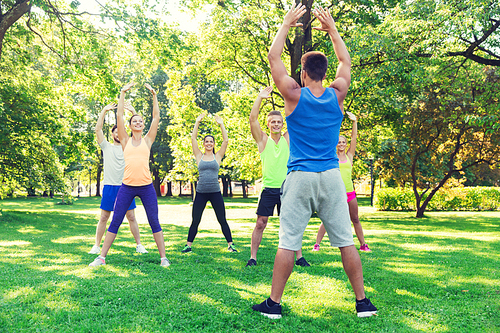 fitness, sport, friendship and healthy lifestyle concept - group of happy teenage friends or sportsmen exercising  at boot camp