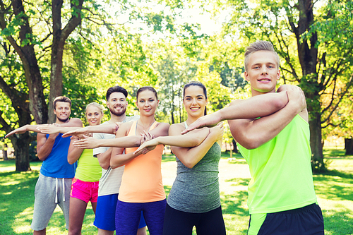 fitness, sport, friendship and healthy lifestyle concept - group of happy teenage friends or sportsmen exercising and stretching hands at boot camp