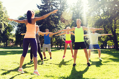 fitness, sport, friendship and healthy lifestyle concept - group of happy teenage friends or sportsmen exercising at boot camp